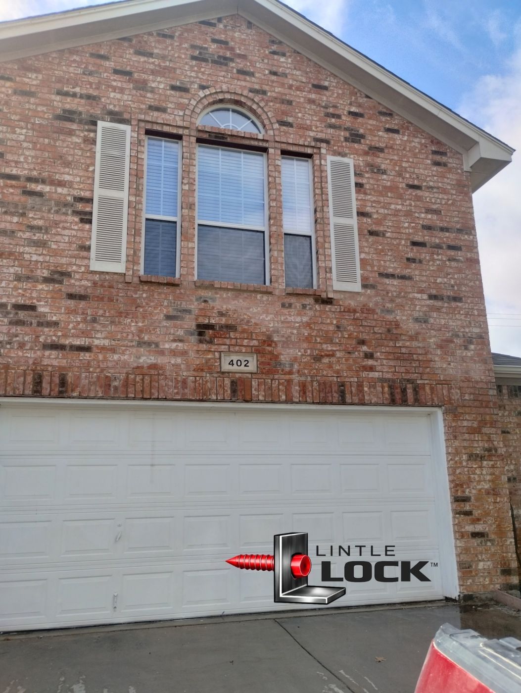 A two-story brick home with sagging brickwork above double garage