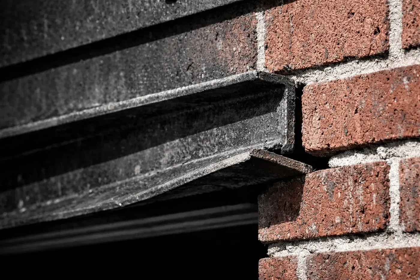 Torsional twisting in a garage lintel showing why repairing brick wall projects fail without structural locking.
