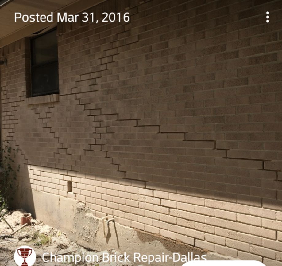 Stair-step cracking across a residential brick wall indicating masonry movement