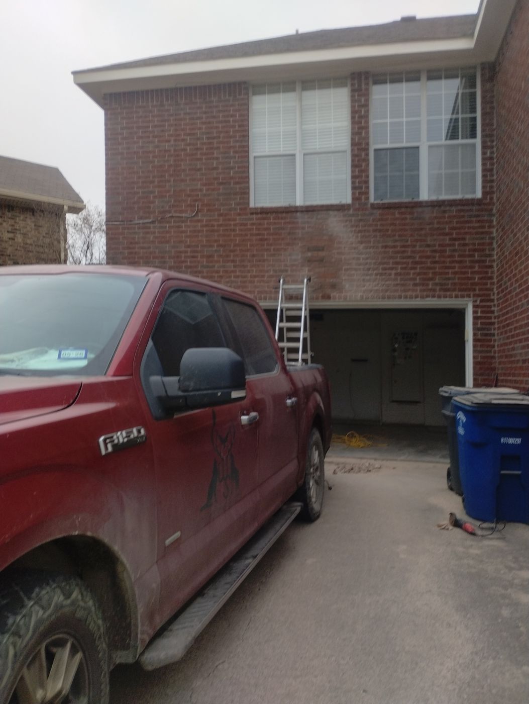 A Champion Brick Repair & Whitestone Construction truck is parked in front of a two-story brick house