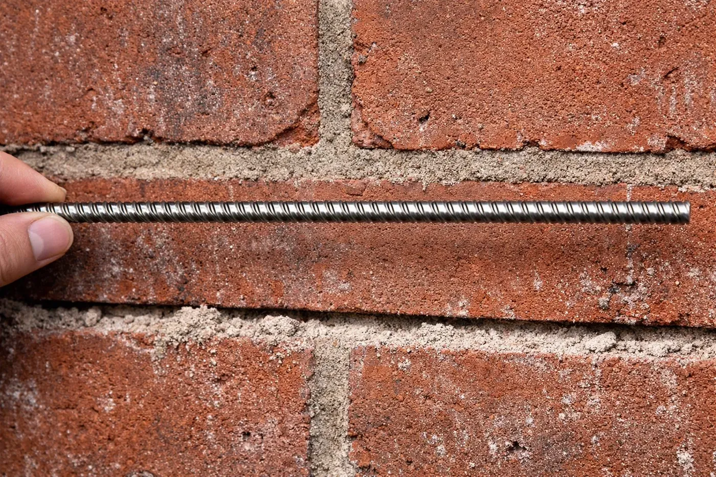 8mm stainless steel Champion Stitching Rod being installed in a prepared brick mortar joint for structural repair.