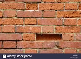 Section of a brick wall showing a missing brick and visible mortar wear
