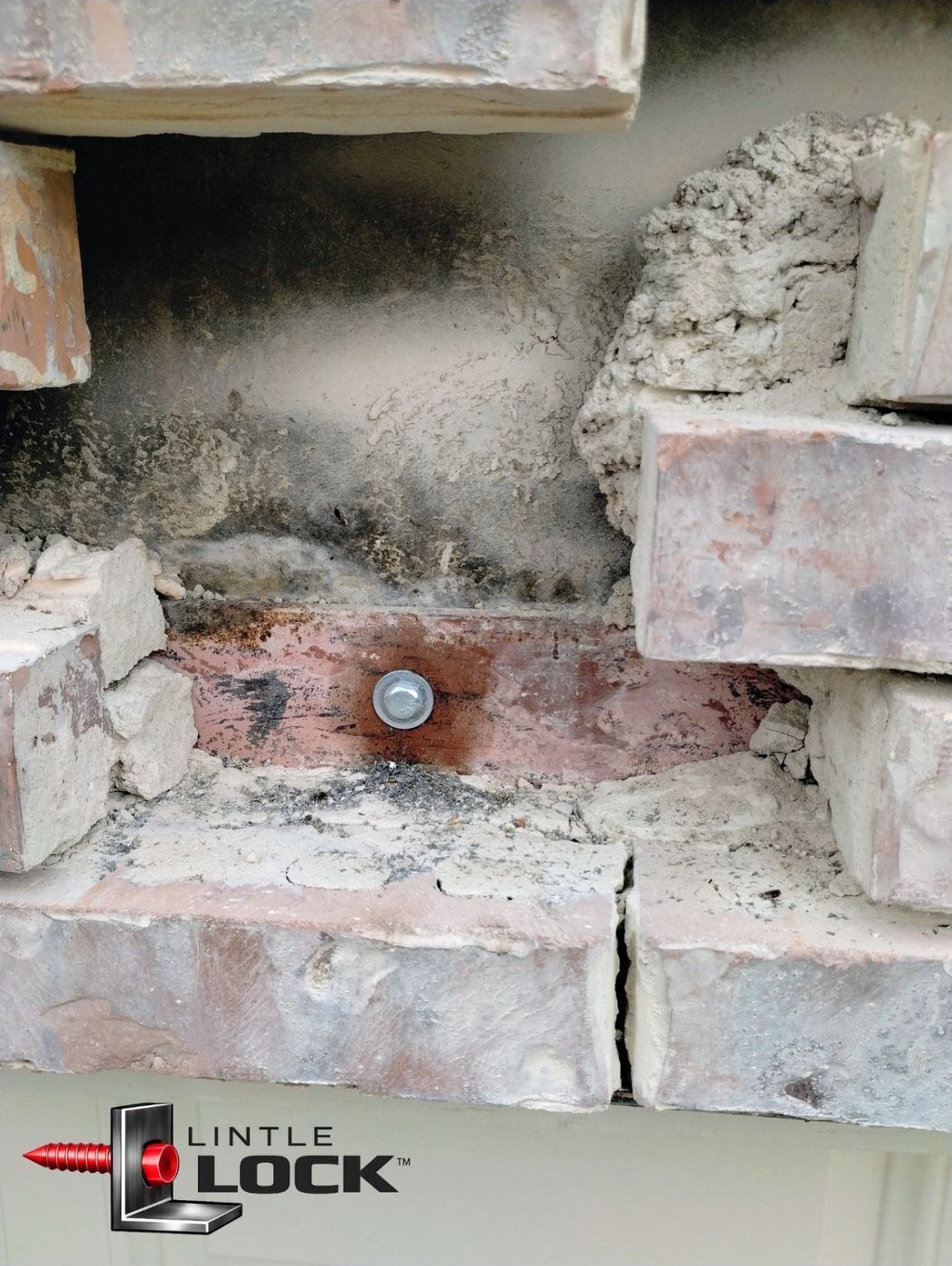 Visible damage to a brick wall above a garage door