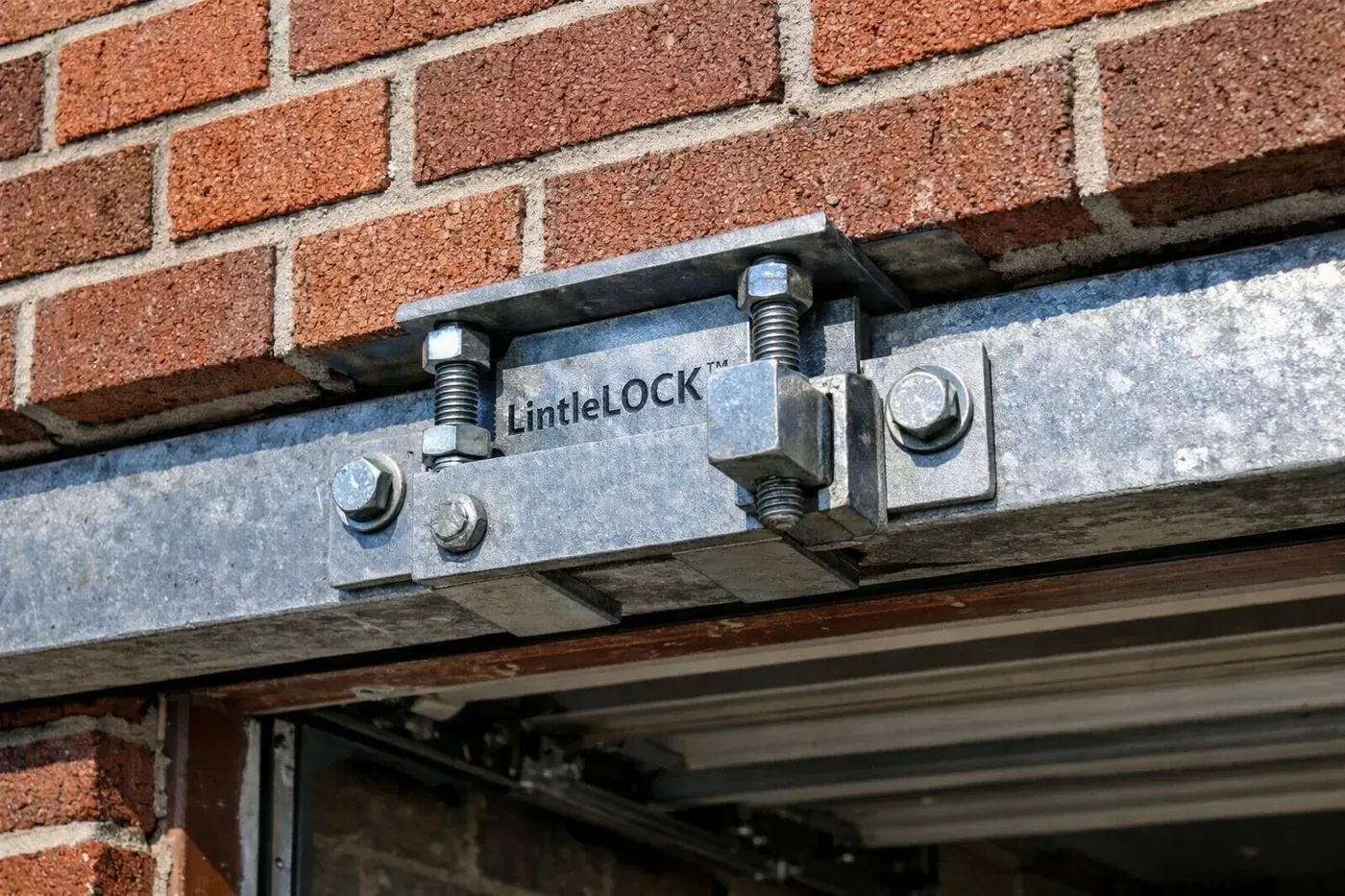 Close-up of LintleLOCK™ hardware installed in a brick garage header for permanent structural masonry repair.